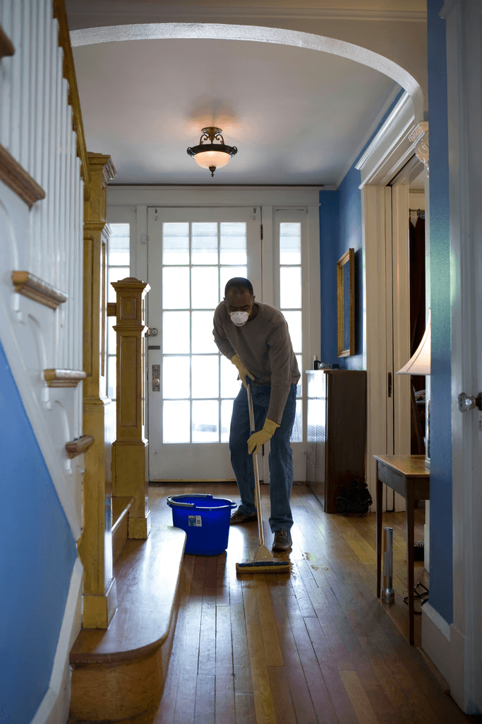 Person cleaning a wooden floor